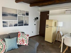 un soggiorno con divano e frigorifero di Casa Campiglia a Nebbiuno