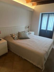 a bedroom with a large white bed with a window at Casa Campiglia in Nebbiuno