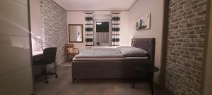 a bedroom with a bed and a brick wall at Bauernhaus Schunck im Bliesgau in Blieskastel
