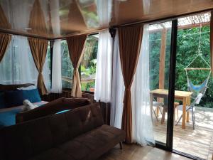 salon z kanapą i przesuwnymi szklanymi drzwiami w obiekcie Cool Waters Jungle Villas w mieście Uvita