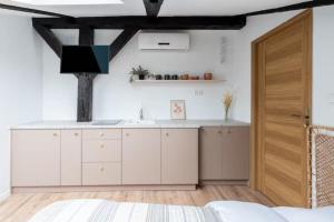 a kitchen with white cabinets and a wooden door at Wiślna Old Town Apartments in Kraków