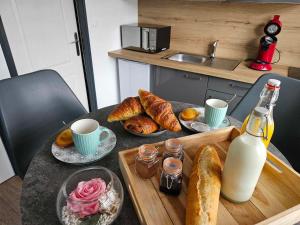 een tafel met brood en een fles melk en drankjes bij L'oxybulles et Spa in Friville-Escarbotin