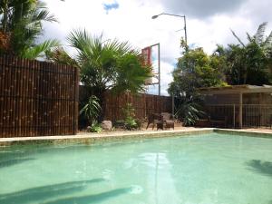 a large swimming pool in a yard with a fence at Pacific Paradise Airport Motel in Pacific Paradise 