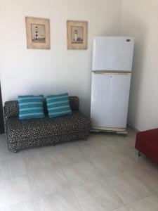 a living room with a couch and a refrigerator at Casa Bella Suit in Salinas