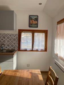 a kitchen with a wooden table and a window at Appartement proche des thermes d'Allevard les Bains in Saint-Pierre-dʼAllevard