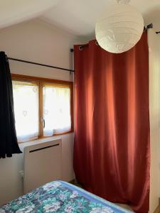 a bedroom with a red curtain next to a bed at Appartement proche des thermes d'Allevard les Bains in Saint-Pierre-dʼAllevard
