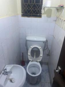 a small bathroom with a toilet and a sink at PiperZ in Entebbe