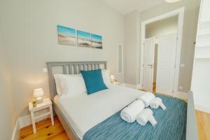 ein Schlafzimmer mit einem großen weißen Bett mit blauen Kissen in der Unterkunft Bonfim Premium by Hosty in Porto