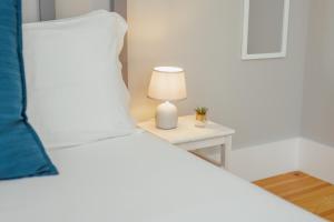 Schlafzimmer mit einem Bett und einer Lampe auf einem Tisch in der Unterkunft Bonfim Premium by Hosty in Porto