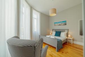 ein Schlafzimmer mit einem Bett und einem Stuhl darin in der Unterkunft Bonfim Premium by Hosty in Porto