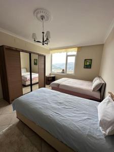 a bedroom with two beds and a mirror at Villa Amesia in Amasya
