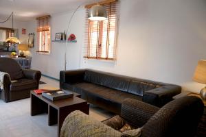 sala de estar con sofá de cuero y sillas en PALMITO, en Villena