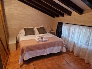 Un dormitorio con una cama con toallas. en Adrimar, en Quijas