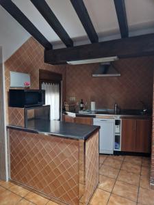Una cocina con encimera negra en una habitación. en Adrimar, en Quijas