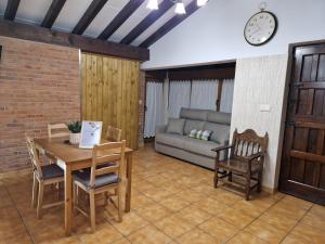 Una sala de estar con una mesa y sillas y un sofá. en Adrimar, en Quijas
