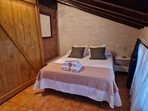 Un dormitorio con una cama con toallas. en Adrimar, en Quijas