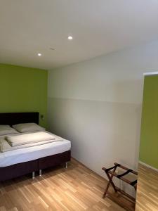 Cama en habitación con paredes verdes y blancas en Tondose Apartment, en Dortmund