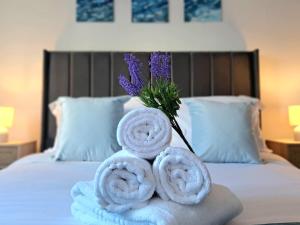 een stapel handdoeken op een bed met een vaas bloemen bij Cozy, Charming 3-Bedroom Home in Chester- Free Parking- Sleeps Up To 6 in Chester