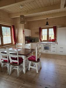 eine Küche mit einem Tisch und Stühlen im Zimmer in der Unterkunft Hasiorówka. Dom w górach in Złatna