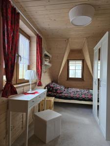 Zimmer mit einem Schreibtisch und einem Bett in einer Hütte in der Unterkunft Hasiorówka. Dom w górach in Złatna