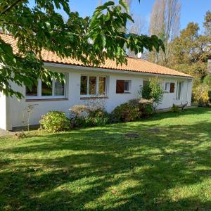 una casa blanca con un patio de césped en La Gisière, Chambres d'hôtes, en Challans