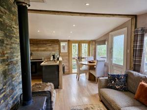a kitchen and living room with a stove at Rowan Tree Lodge with hot tub in Hope Bagot