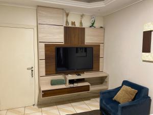 a living room with a flat screen tv on a wall at Pousada Paisagem in Jaraguá do Sul
