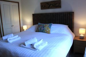 ein Bett mit zwei Handtüchern und zwei Kissen darauf in der Unterkunft Mi Casa Su Casa - Mount Brioni in Downderry