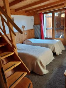 Zimmer mit 2 Betten und einer Treppe in einer Hütte in der Unterkunft Hotel Bergerie Chatel in Châtel