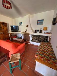 a living room with a red couch and a fireplace at Majella Green House in Roccamontepiano