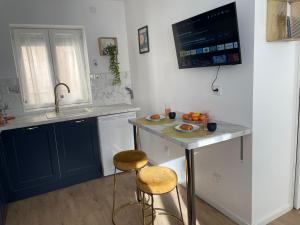 a kitchen with a sink and a counter with two stools at Le Requiem -Terrasse -Climatisation -Gare in Montluçon +10 photos