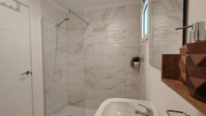 La salle de bains est pourvue d'une douche et d'un lavabo. dans l'établissement La Niña Apartment, Puerto del Rosario, à Puerto del Rosario