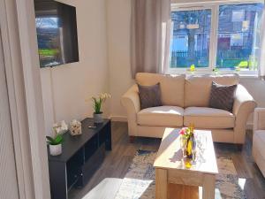 uma sala de estar com um sofá e uma mesa em Cozy, Charming 3-Bedroom Home in Chester- Free Parking- Sleeps Up To 6 em Chester