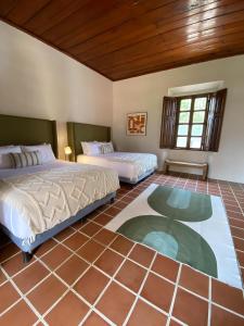 2 Betten in einem Zimmer mit Fliesenboden in der Unterkunft Mestizo Antigua Cortijo in Ciudad Vieja