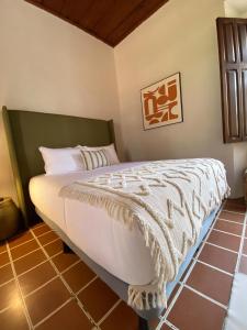 a bedroom with a bed with a white comforter at Mestizo Antigua Cortijo in Ciudad Vieja