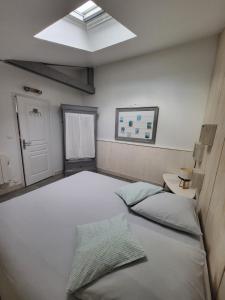 a bedroom with two beds and a skylight at L'atelier, dépendance de charme, Ste Mère Église in Sainte-Mère-Église