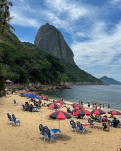 un grupo de personas sentadas en una playa con sombrillas en Apartament Copa Charmed HIR 43, en Río de Janeiro