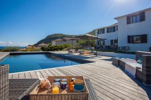 a tray of food on a table next to a swimming pool at VILLA KIM SISCU a 300m de la plage in Sisco