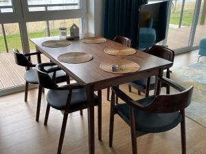 a dining room table with chairs and a wooden table at Ostseeperle in Dziwnów