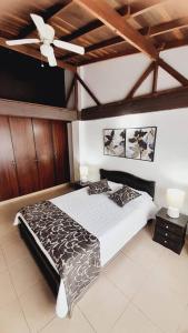 1 dormitorio con 1 cama y ventilador de techo en Apartamento Turístico En Calarcá Quindío, en Calarcá