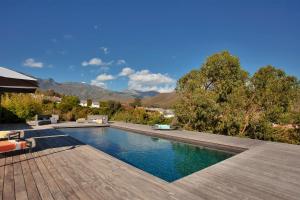 a swimming pool in a yard with a wooden deck at VILLA KIM SISCU a 300m de la plage in Sisco