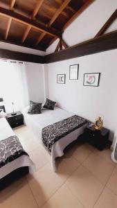 Un dormitorio con 2 camas y un banco. en Apartamento Turístico En Calarcá Quindío, en Calarcá