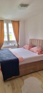 a bedroom with two beds and two windows at Apartman-Stan in Bugojno