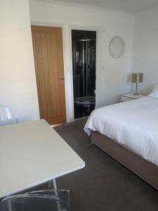 a bedroom with a bed and a table and a door at Mayfield guest rooms in Bromley