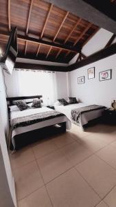 Habitación con 2 camas y techo de madera. en Apartamento Turístico En Calarcá Quindío, en Calarcá