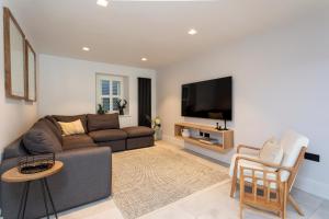 ein Wohnzimmer mit einem Sofa und einem TV in der Unterkunft Kist Accommodates - The Stray Nook in Harrogate
