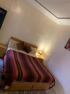 een slaapkamer met een bed met een gestreepte deken bij Riad Salma de Groot in Marrakesh