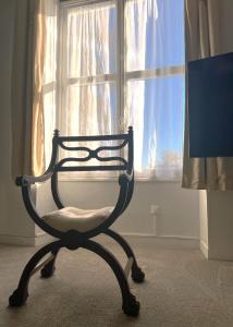 a chair sitting in front of a window at The Originals Boutique, Hôtel Le George , Loches in Loches
