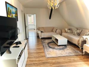 a living room with a couch and a tv at Charmantes Apartment mit kostenlosem Parkplatz 