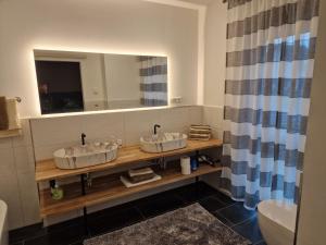 een badkamer met 2 wastafels en een spiegel bij Ferienwohnung Engel in Grebenstein